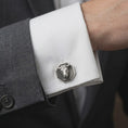 Load image into Gallery viewer, An oxidized bull head cufflink is worn on a white shirt cuff in a close-up lifestyle shot, styled with a dark suit for a bold masculine look.
