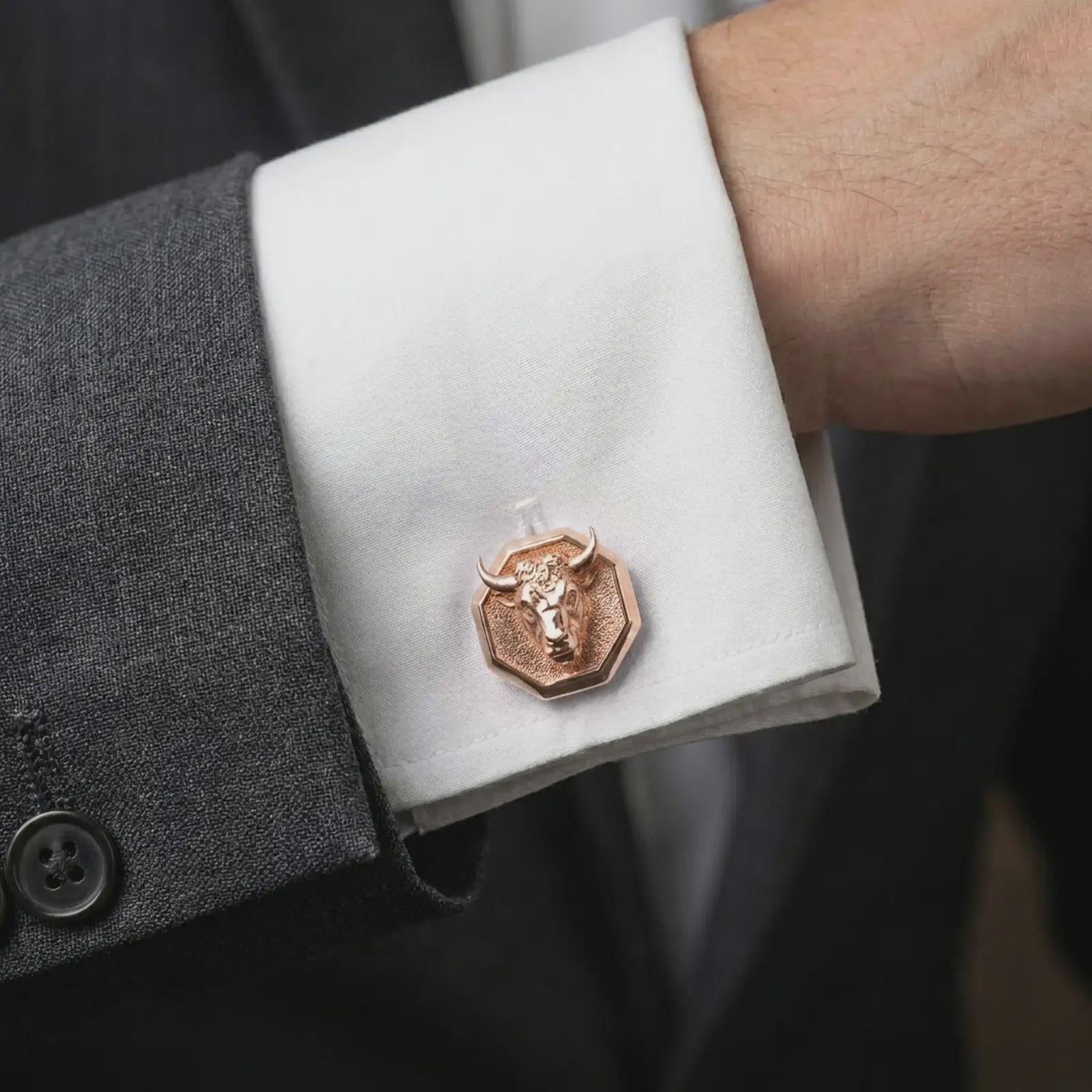 A rose gold plated bull head cufflink is worn on a shirt cuff in a close-up lifestyle composition, highlighting its octagon frame and powerful bull design.