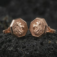 Load image into Gallery viewer, Rose gold plated lion profile cufflinks are photographed on porous volcanic rock in a close-up studio composition with refined luxury lighting and detailed lion features.
