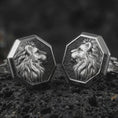 Load image into Gallery viewer, An oxidized lion profile cufflink pair rests on dark volcanic rock in a macro studio close-up, showing a sculpted big cat head with flowing mane inside octagon frames.
