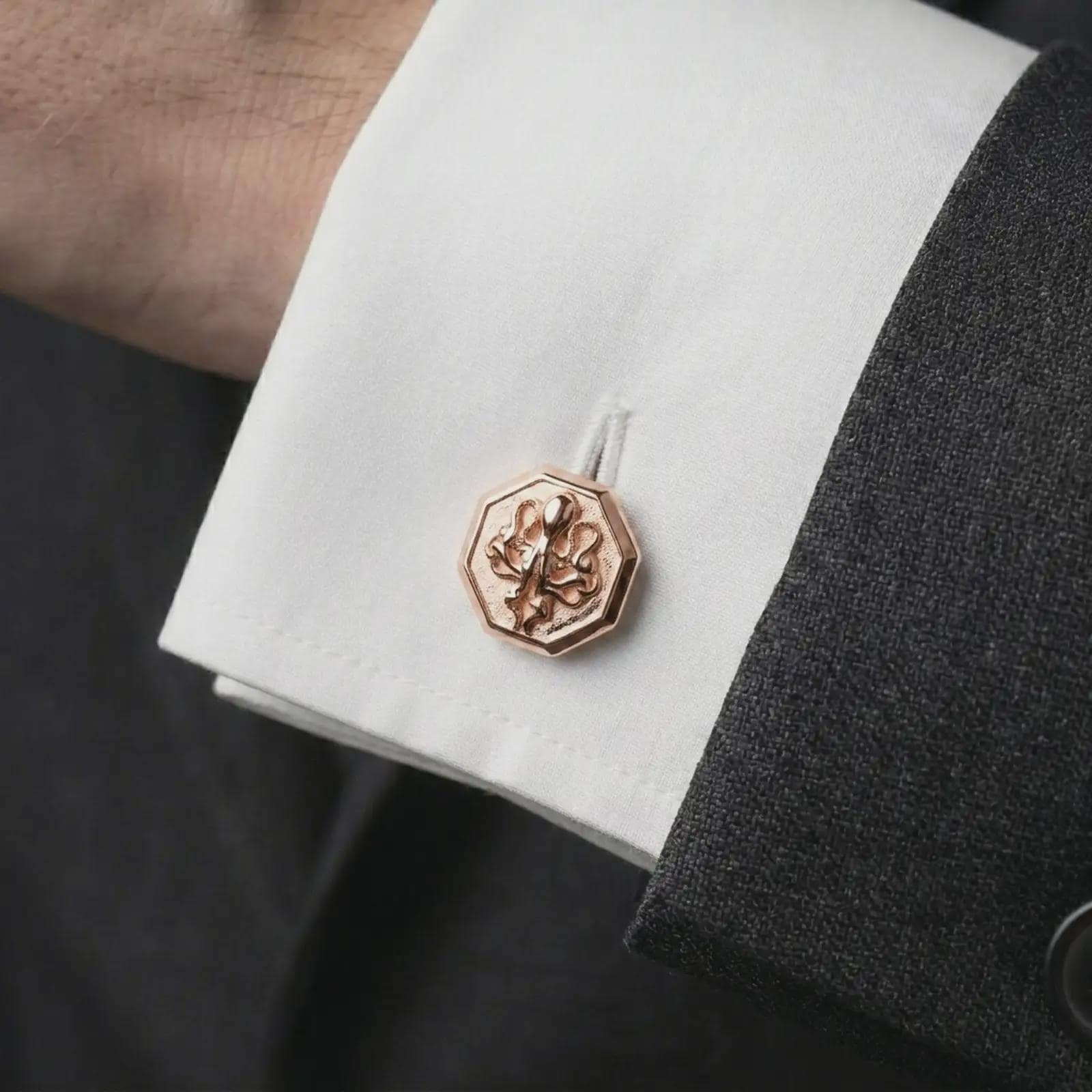A rose gold plated octopus cufflink is worn on a shirt cuff in a close-up lifestyle composition, highlighting its octagon frame and sculpted octopus design.