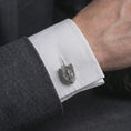Load image into Gallery viewer, An oxidized Saint Michael cufflink is worn on a white shirt cuff in a close-up lifestyle shot, styled with a dark suit as a meaningful Catholic accessory.
