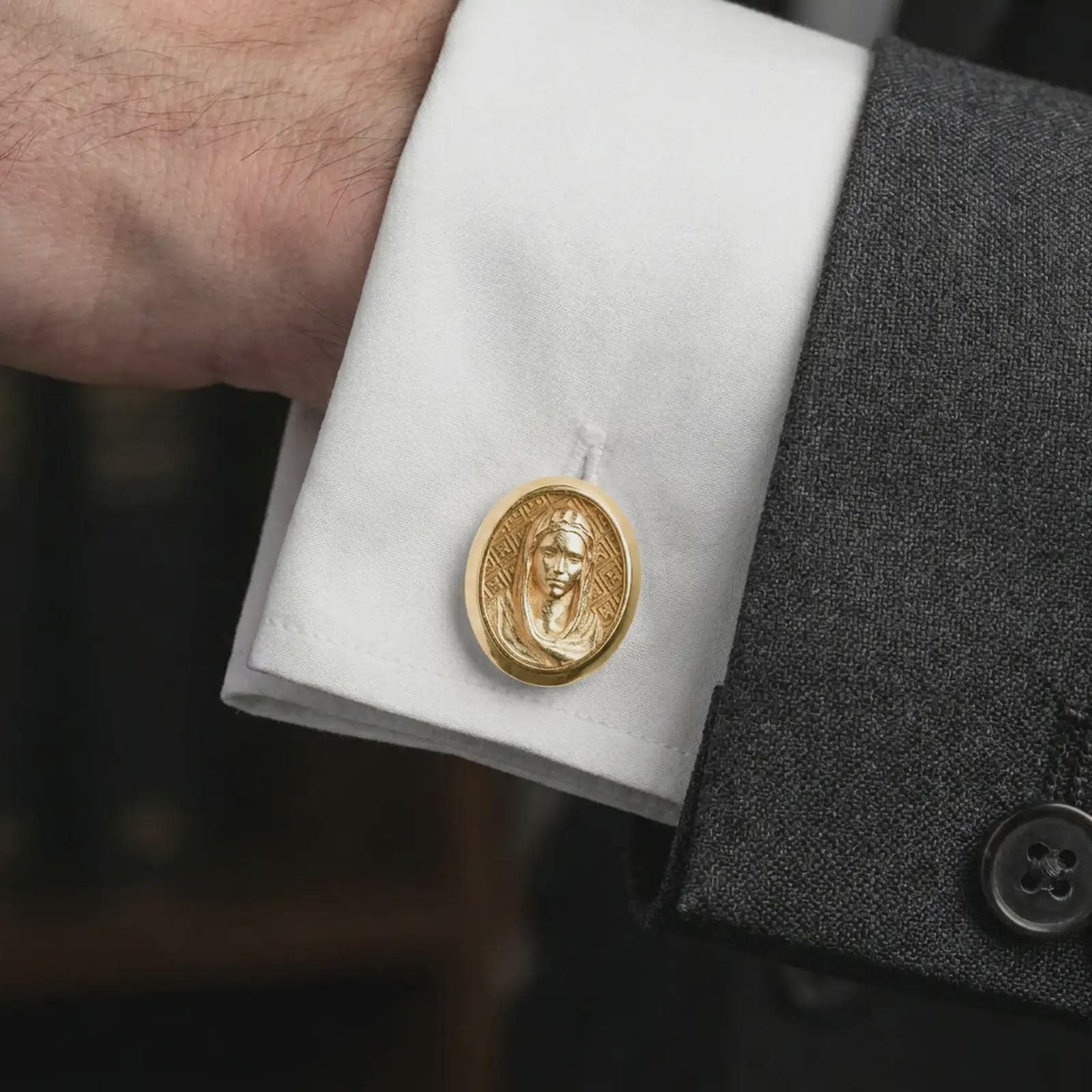 A gold plated Virgin Mary cufflink is worn on a white cuff in a close-up lifestyle shot, styled as a thoughtful religious gift for Catholic men.