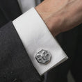 Load image into Gallery viewer, A polished silver ram skull cufflink is worn on a shirt cuff in a premium close-up lifestyle image, showing the sculpted horned skull clearly.
