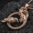 Load image into Gallery viewer, Rose gold plated Hugin and Munin ravens pendant necklace on textured volcanic rock, detailed macro product shot with soft warm reflections and symbolic Odin’s ravens styling.

