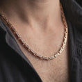Load image into Gallery viewer, Rose gold plated Greek key chain necklace is worn on the neck in a close-up lifestyle composition, highlighting the geometric meander pattern and refined chain design.
