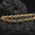 Load image into Gallery viewer, Gold plated ornamental link chain arranged across black rock, emphasizing the repeating circle pattern and decorative handcrafted texture.
