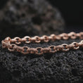 Load image into Gallery viewer, Rose gold plated ornamental chain necklace shown on volcanic stone, with detailed bar links and raised round motifs visible in close-up.
