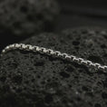 Load image into Gallery viewer, Polished silver box chain necklace on volcanic stone, highlighting the compact geometric links and clean reflective finish.
