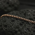 Load image into Gallery viewer, Rose gold plated box chain necklace on dark volcanic stone, showing warm tone contrast with the precise square-link construction.
