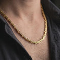 Load image into Gallery viewer, Gold plated Greek key chain necklace is worn on the neck in a close-up lifestyle shot, styled as a meaningful ancient Greek gift for men.
