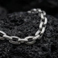 Load image into Gallery viewer, Oxidized sterling silver anchor link bracelet arranged on black volcanic rock, showing its rounded mariner-style links.
