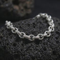 Load image into Gallery viewer, Polished silver ornamental bracelet arranged on dark volcanic stone, featuring rounded connector links and decorative bar-shaped elements.
