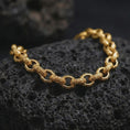 Load image into Gallery viewer, Gold plated ornamental link bracelet on black lava rock, designed with repeating circle links and detailed bead-like accents.
