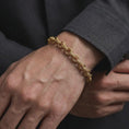 Load image into Gallery viewer, Gold plated circle link bracelet worn on the wrist, combining artisan-inspired detailing with a structured masculine chain profile.
