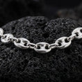 Load image into Gallery viewer, The polished silver 11mm mariner necklace is arranged across textured black volcanic rock, highlighting its broad nautical links, smooth contours, and articulated construction in a premium macro photograph.
