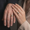 Load image into Gallery viewer, The rose gold plated dolphin wave ring is worn on a couple’s fingers, showcasing the flowing marine relief and coordinated unisex design in an elegant close-up lifestyle shot.
