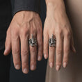 Load image into Gallery viewer, An oxidized scorpion ring is worn on a man’s finger, displaying the dark recessed details, raised tail, curved stinger, and bold sterling silver claw design in a masculine lifestyle close-up.
