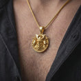 Load image into Gallery viewer, A gold plated Bushido samurai pendant is worn on a man’s neck with dark clothing, highlighting the bold warrior design and intricate Japanese armor details in a refined masculine close-up.
