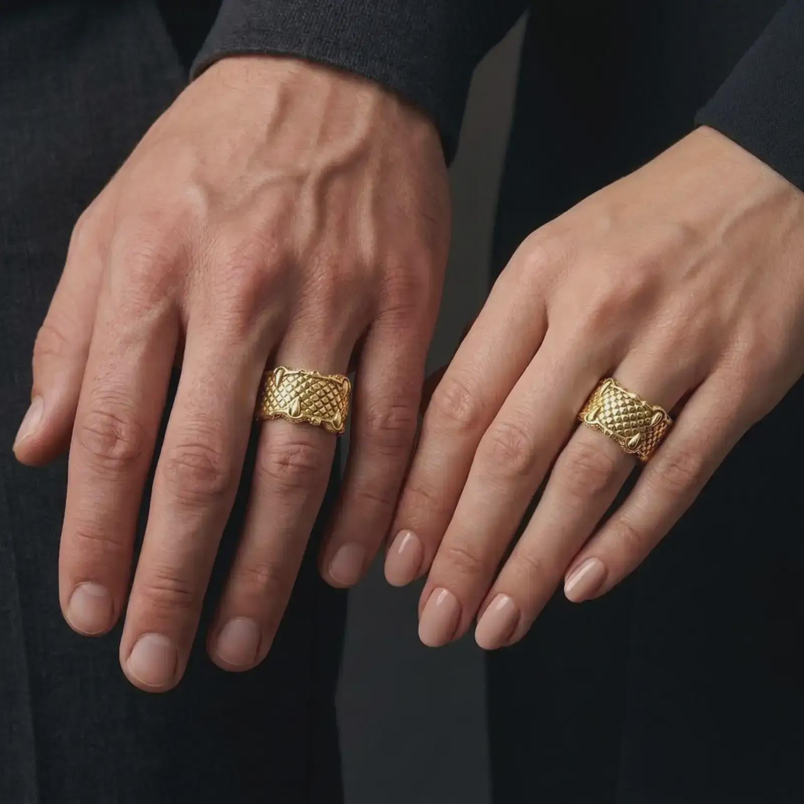 A gold plated dragon scale ring is worn on a man’s and woman’s fingers, highlighting the sculpted talons and repeating fantasy pattern as a bold matching couple design.