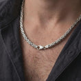 Load image into Gallery viewer, The polished silver Byzantine necklace is worn on a man’s chest, showing the rounded interlocking links, substantial 6mm width, and classic sterling silver styling in a premium lifestyle photograph.
