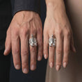 Load image into Gallery viewer, The polished silver scorpion ring is worn on a man’s finger, showing the sculpted arachnid body, segmented tail, textured claws, and substantial gothic band in a premium lifestyle photograph.
