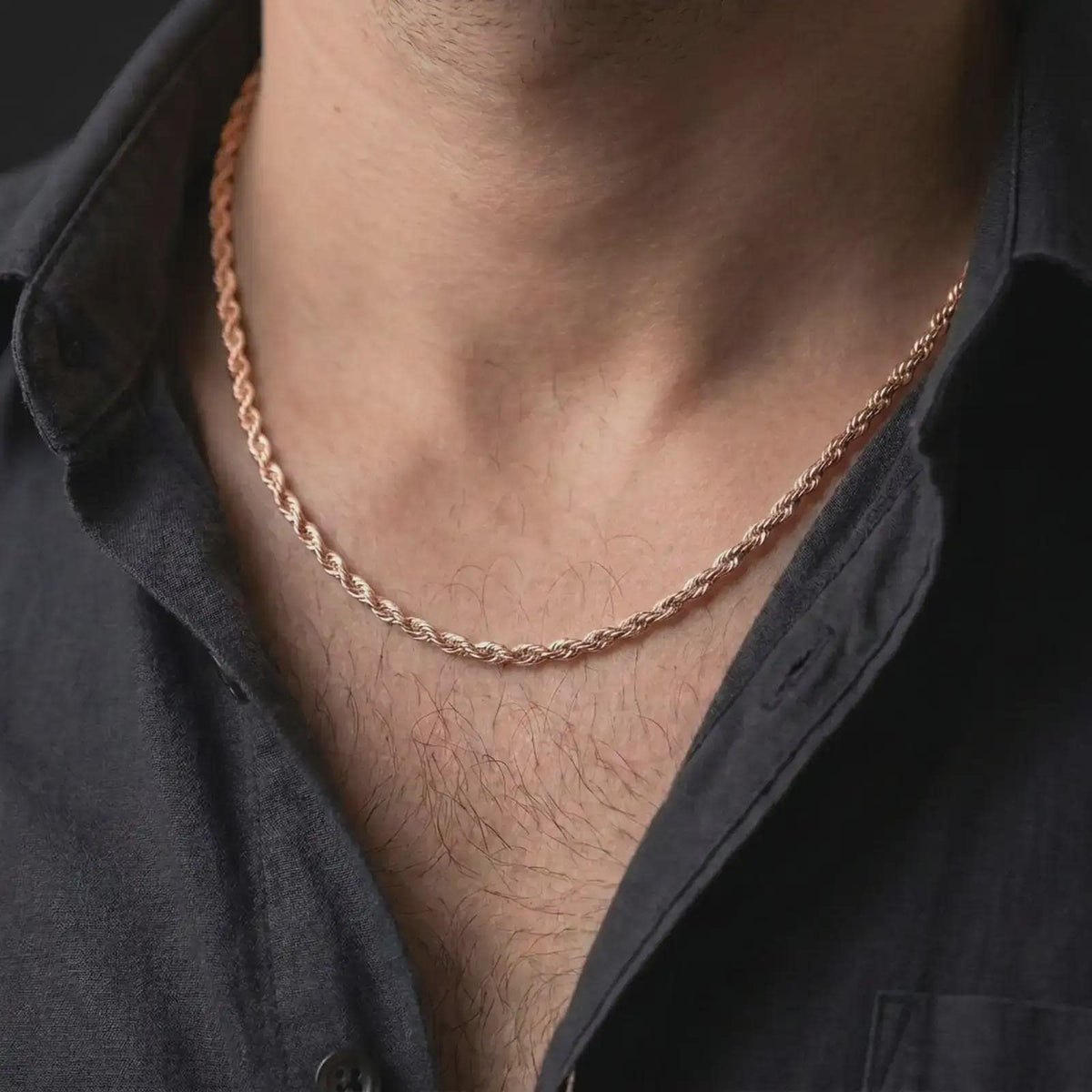 The rose gold plated rope chain necklace is worn naturally on a man’s chest, showcasing the twisted sterling silver structure, warm finish, and elegant masculine jewelry design.