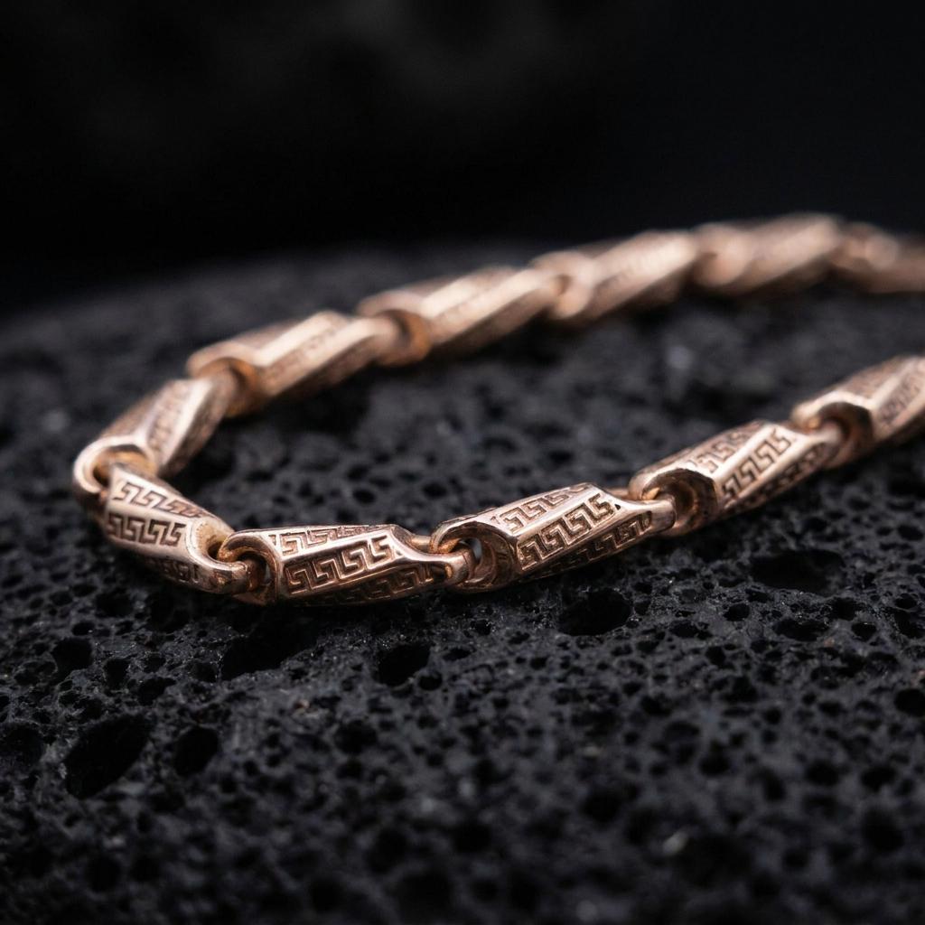The rose gold plated meander link necklace is arranged on black volcanic rock, emphasizing its geometric Greek key engravings, smooth connectors, and refined chain structure in a macro studio image.