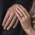 Load image into Gallery viewer, An oxidized Celtic knot ring is worn on a man’s finger, displaying dark recessed details, raised sterling silver interlacing, and a bold masculine profile in a close-up lifestyle shot.
