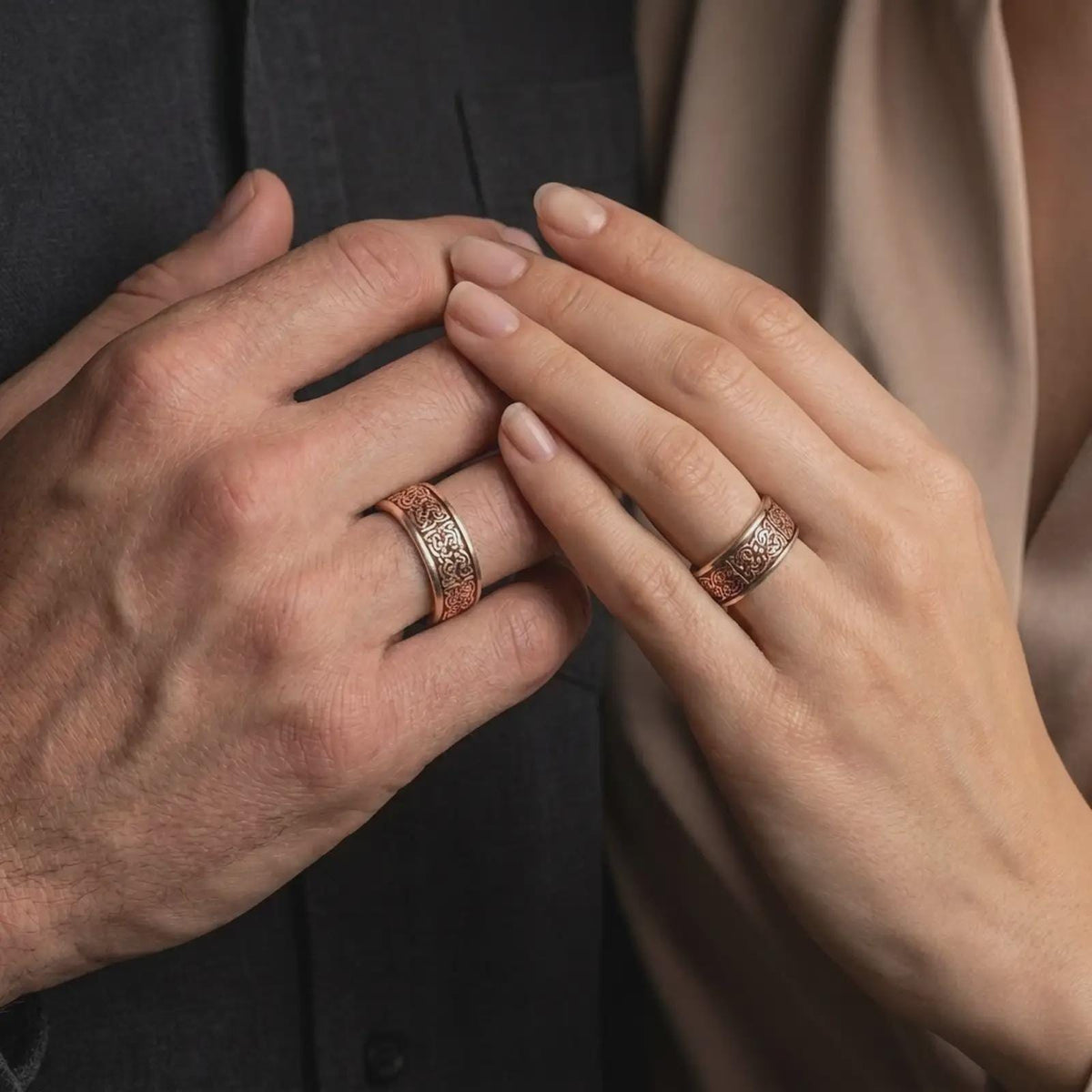 A rose gold plated Celtic spinner wedding band is worn on a hand in a refined lifestyle image, showcasing the detailed knotwork and timeless unisex Irish ring style.