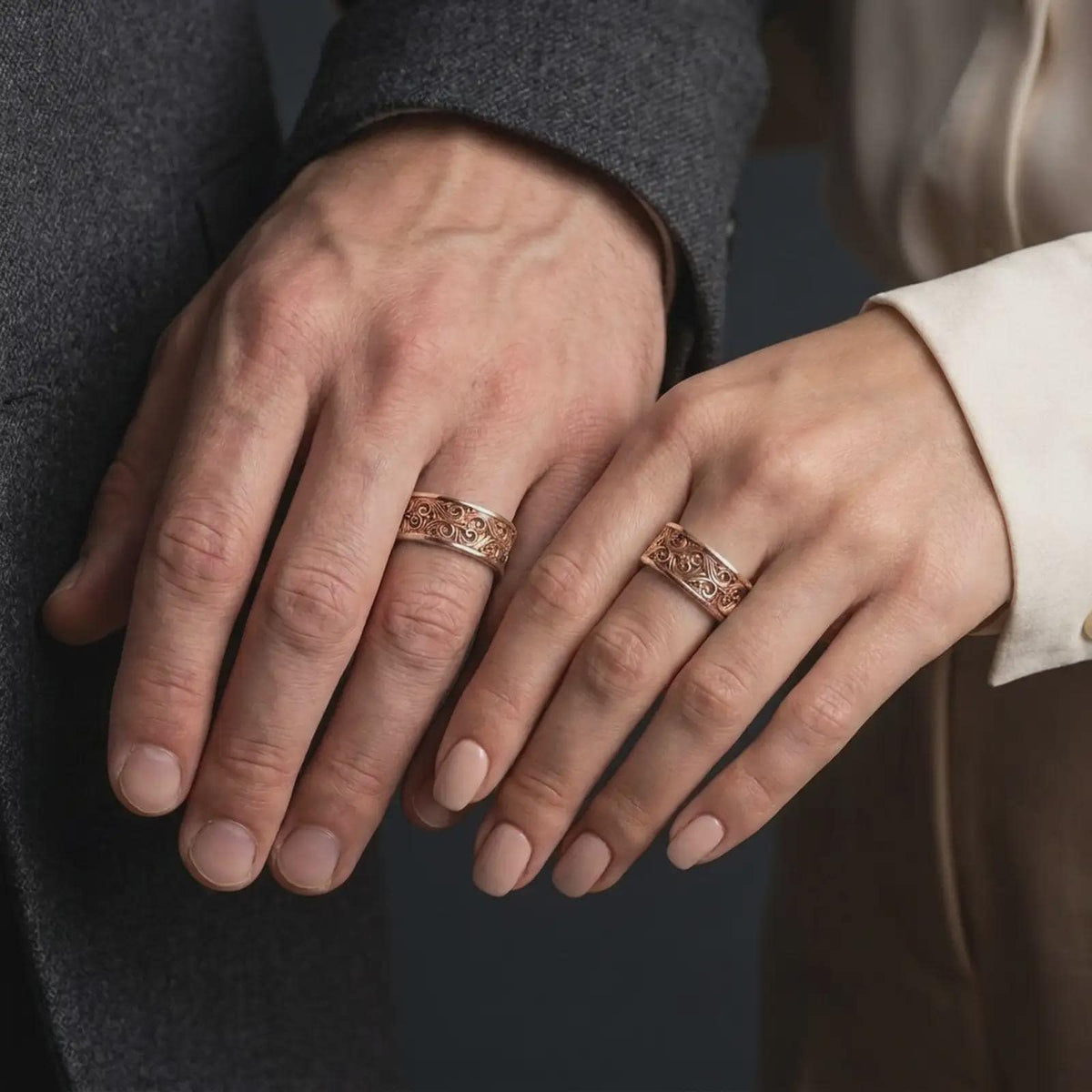 The rose gold plated scroll spinner band is worn on a finger, showcasing flowing botanical details, rounded edges, and an elegant unisex fidget ring design.