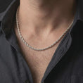 Load image into Gallery viewer, The polished silver rope chain necklace is worn on a man’s chest, showing the slim 3mm width, twisted link texture, and refined everyday jewelry style in a premium lifestyle photograph.
