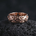 Load image into Gallery viewer, The rose gold plated Byzantine chain ring is arranged on black volcanic rock, emphasizing the woven link construction, dimensional relief, and refined statement band design in a detailed macro image.

