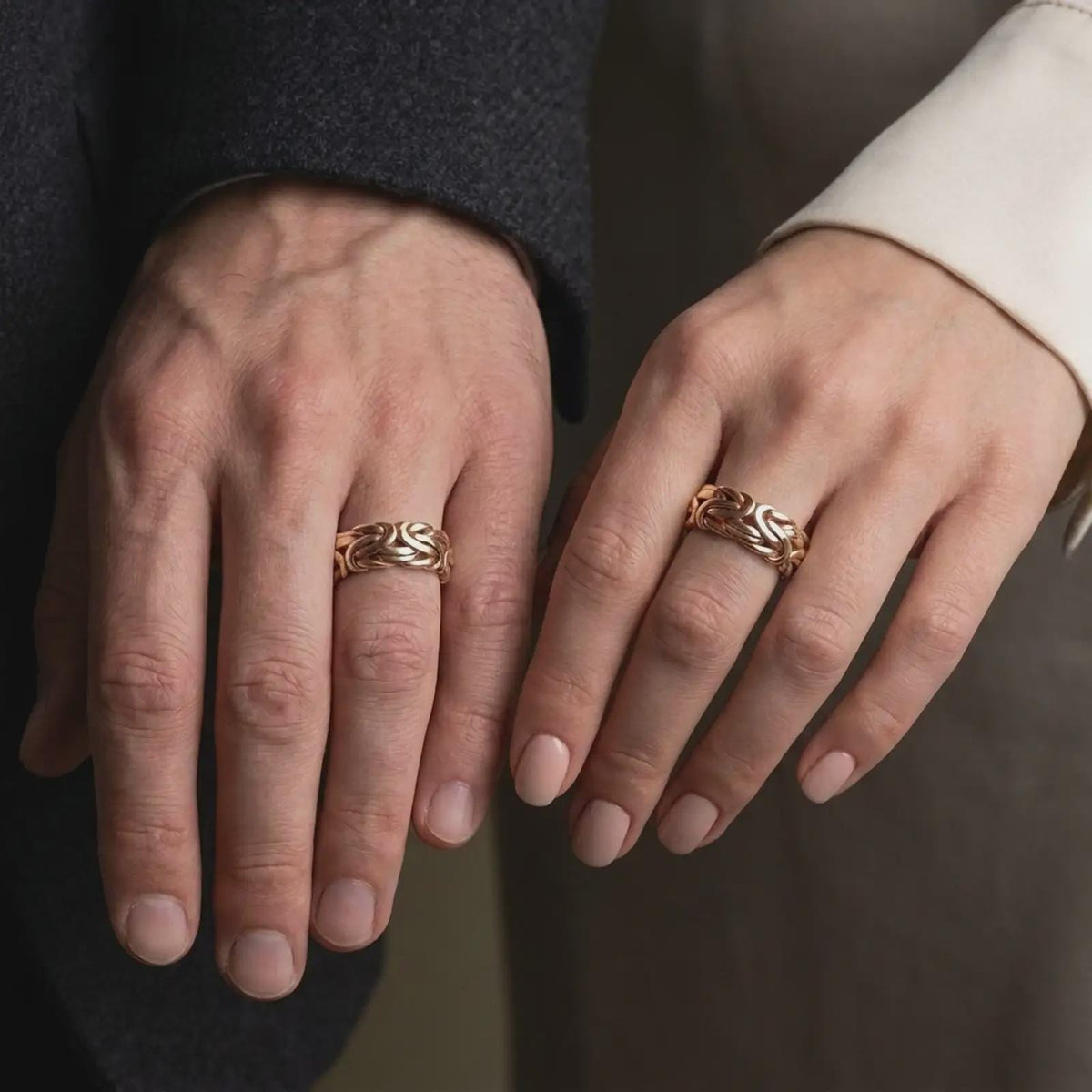 The rose gold plated Byzantine chain band ring is worn on a finger, showcasing the sculpted interlocking links, wide profile, and elegant unisex statement jewelry design.