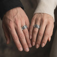 Load image into Gallery viewer, The polished silver carp and wave ring is worn on a finger, showing the continuous aquatic pattern and refined unisex wedding band style in a premium lifestyle photograph.
