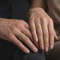 Load image into Gallery viewer, A gold plated Aztec pattern ring is worn on a finger, highlighting the engraved tribal-inspired details, symbolic wide band design, and personalizable wedding ring style in a refined close-up lifestyle shot.
