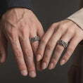 Load image into Gallery viewer, An oxidized sterling silver Asian dragon ring is worn on a finger, displaying the dark recessed background, raised dragon face, detailed scales, and powerful mythical band profile in a close-up lifestyle photograph.
