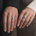 Load image into Gallery viewer, The polished silver Byzantine chain band is worn naturally on a finger, showing the interlocking link pattern, smooth silver finish, and substantial everyday ring design in a premium lifestyle photograph.
