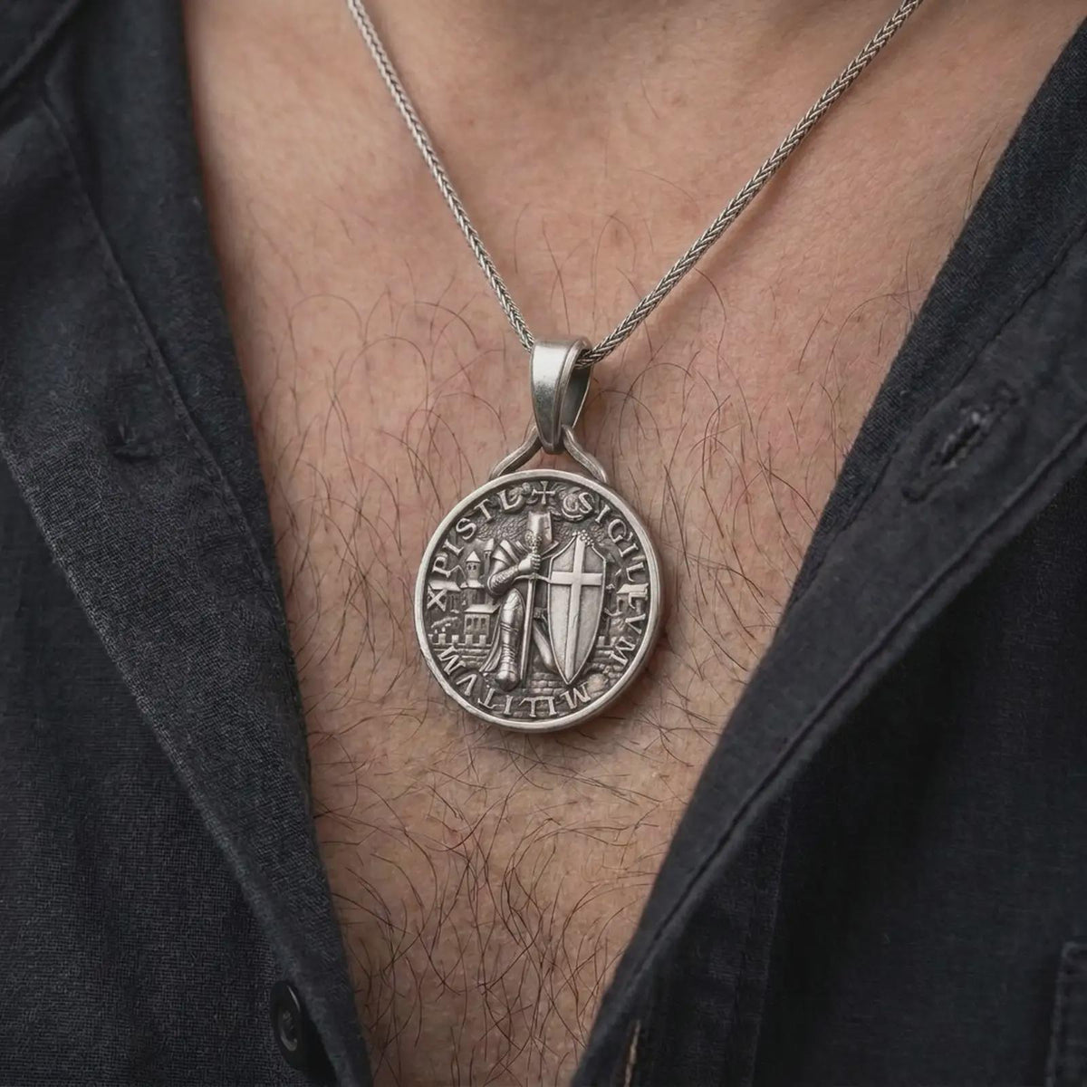 An oxidized sterling silver Templar Knight pendant is worn on the neck, displaying the dark recessed background, raised medieval warrior, cross shield, and round historical medallion profile in a close-up lifestyle photograph.