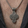 Load image into Gallery viewer, An oxidized sterling silver Saint Michael cross pendant is worn on the neck, displaying the double sided Christian design, protective symbolism, and detailed sculptural cross form in a close-up lifestyle photograph.
