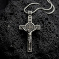 Load image into Gallery viewer, An oxidized sterling silver Saint Benedict crucifix rests on dark volcanic rock, featuring the sculpted Jesus figure, INRI inscription, central Benedict medal, and textured Catholic cross details.

