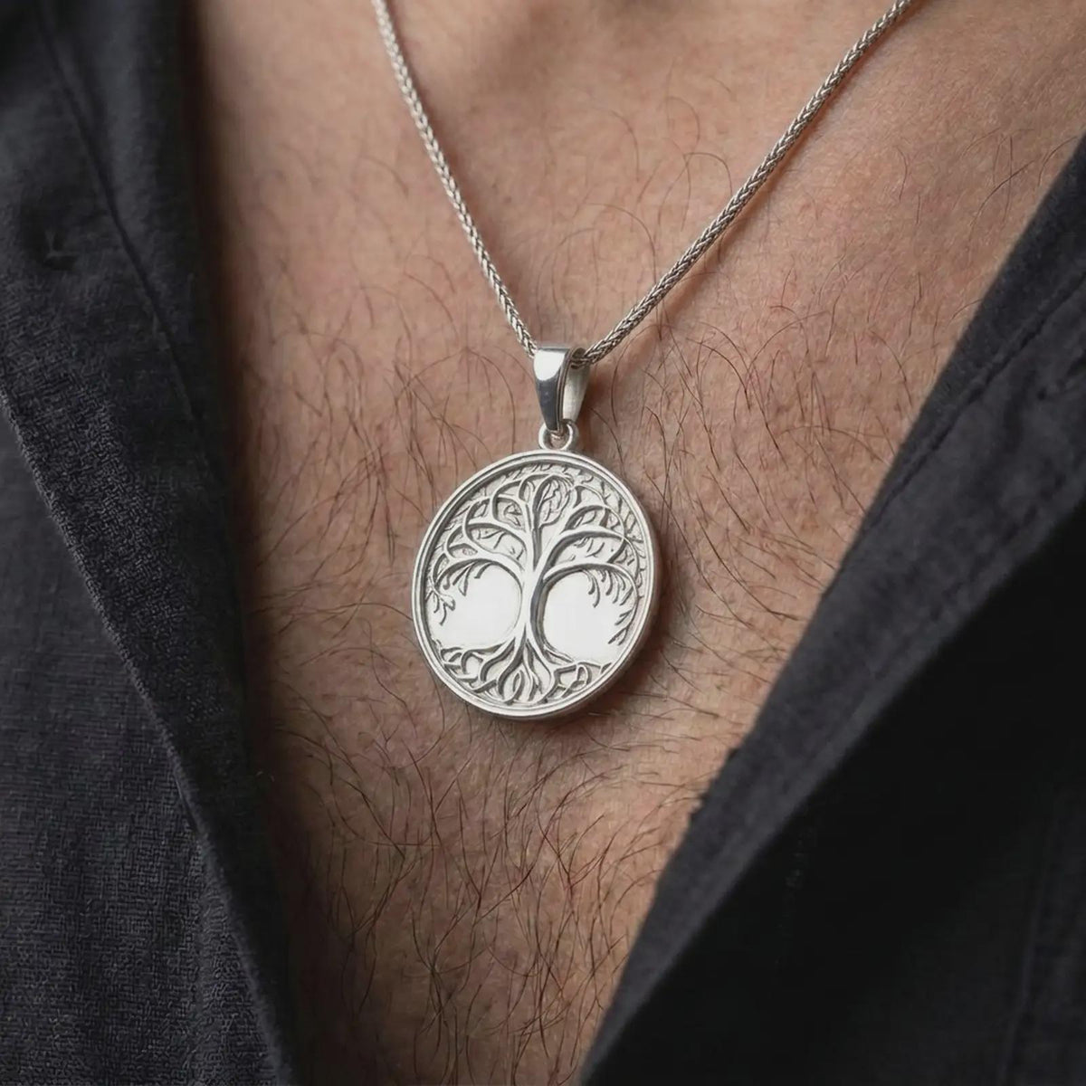 The polished silver Tree of Life necklace is worn naturally on the chest, showing the detailed Yggdrasil design, flowing tree branches, delicate foliage, and elegant circular sterling silver medallion.