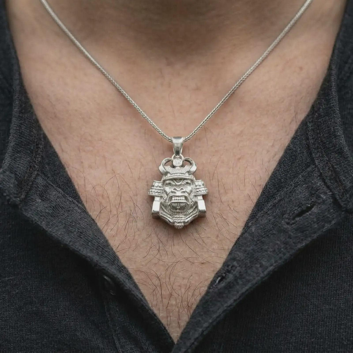 A polished silver King Gorilla Samurai pendant worn on a man's chest, showcasing the detailed gorilla head, decorative helmet crown, sculpted facial features, and bold statement necklace design.