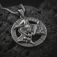 Load image into Gallery viewer, Oxidized sterling silver Trinacria pendant on black volcanic rock, featuring Medusa, three bent legs, and a detailed Greek key border inspired by the traditional symbol of Sicily.
