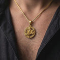 Load image into Gallery viewer, Gold plated Trinacria necklace worn on the chest, displaying the iconic Sicilian three-legged symbol, Medusa centerpiece, and Greek key medallion frame.
