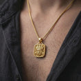 Load image into Gallery viewer, Gold plated Tlaloc necklace worn on the chest, highlighting the Aztec rain god mask, circular eyes, prominent mouth, and detailed ceremonial headdress.
