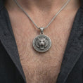 Load image into Gallery viewer, Oxidized sterling silver tiger necklace worn on the chest, showing the roaring tiger head, detailed stripes, sharp fangs, and bold circular pendant profile.
