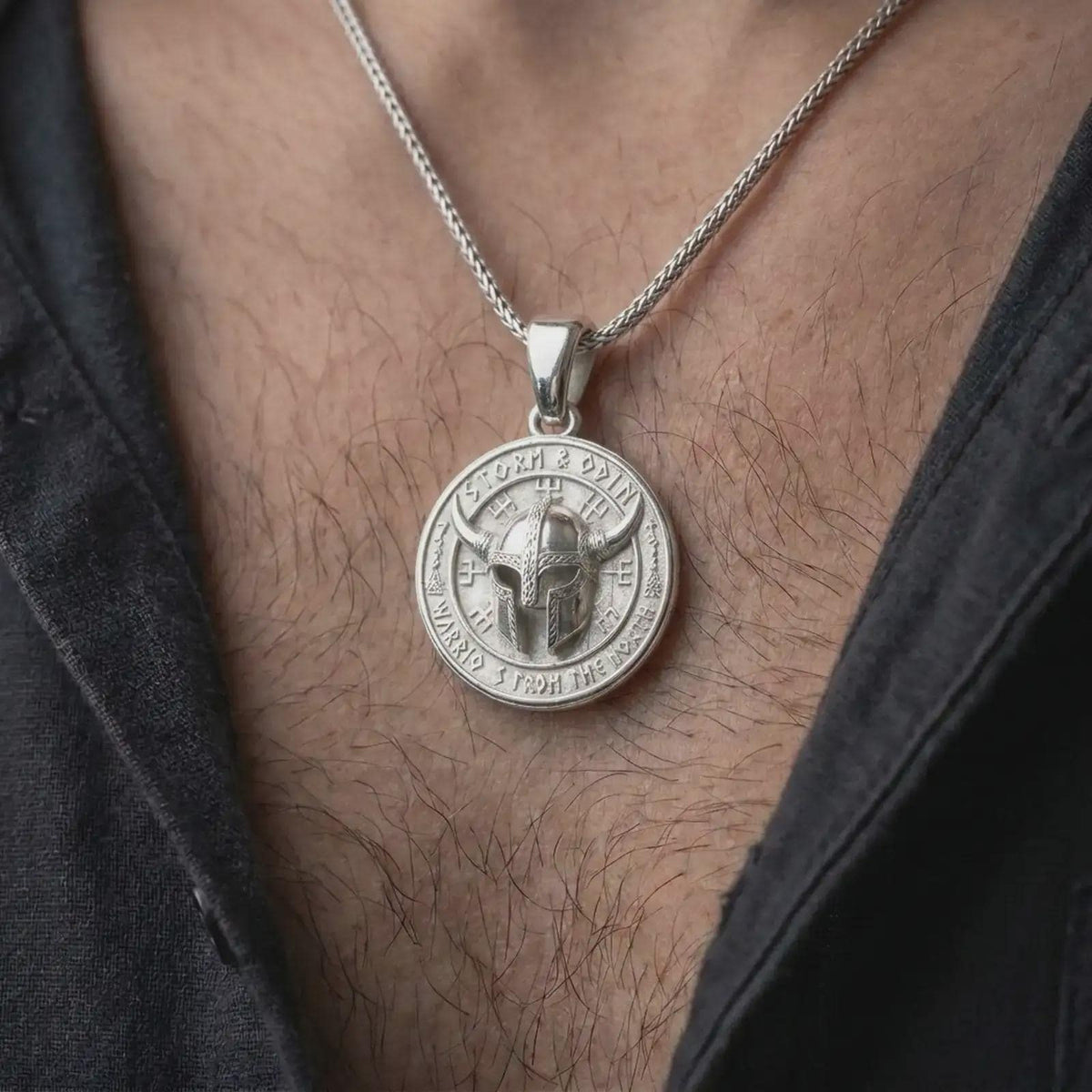 Polished silver Odin pendant worn on the chest, featuring a detailed Viking warrior helmet, rune-inspired markings, engraved border, and masculine Norse mythology style.