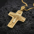 Load image into Gallery viewer, A gold plated Pope Francis cross necklace rests on rugged volcanic rock, showcasing the Good Shepherd carrying a sheep, surrounding flock, dove above, and symbolic Catholic religious design in a luxury macro studio close-up.
