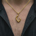 Load image into Gallery viewer, A gold plated Scorpio tail pendant is worn on the chest, highlighting the sculptural armor-like segments, raised details, curved stinger, and powerful astrology-inspired jewelry style in a refined lifestyle shot.
